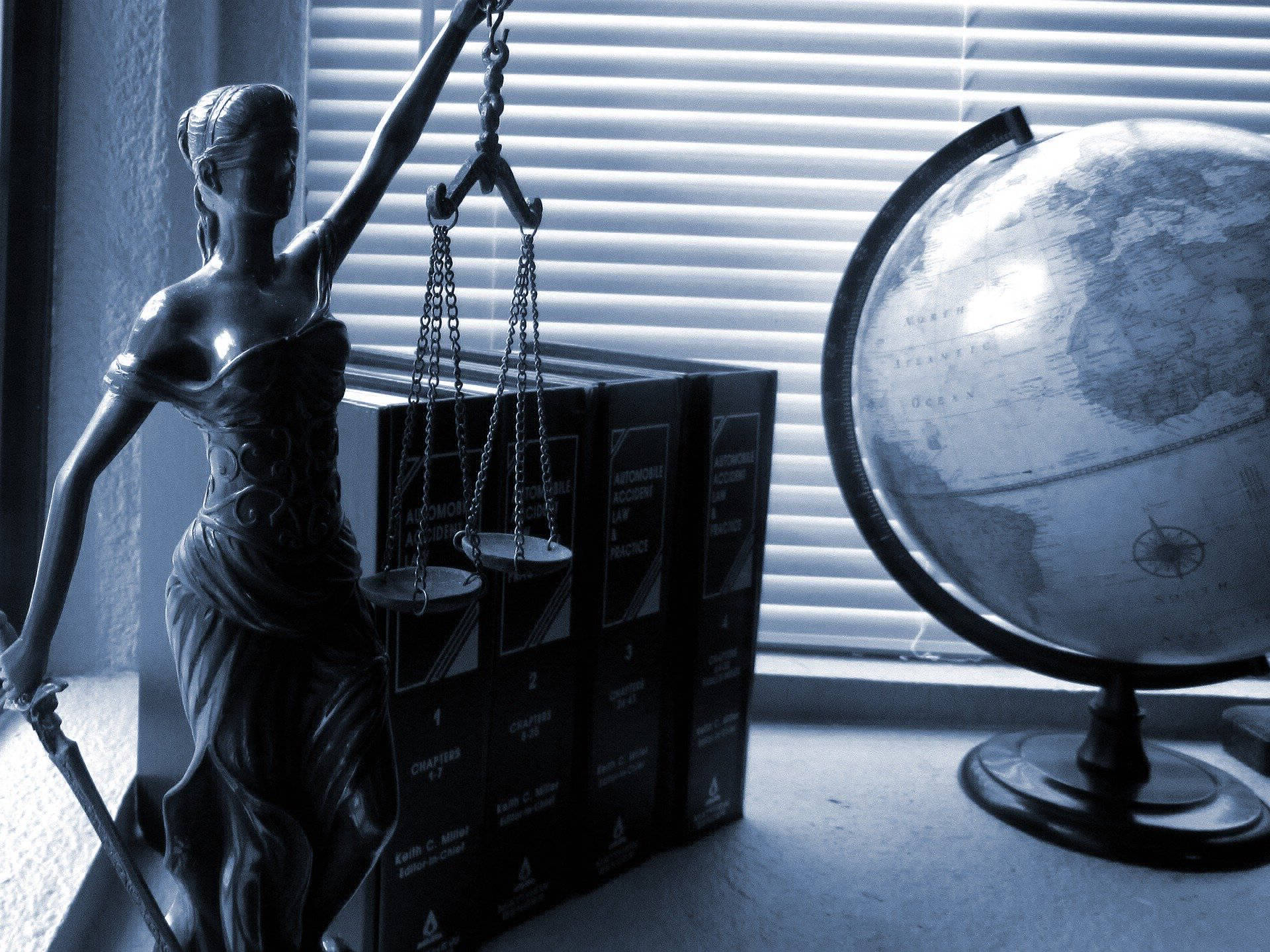 justice of piece statue with scale and globe on a desk set in a blue wash tone